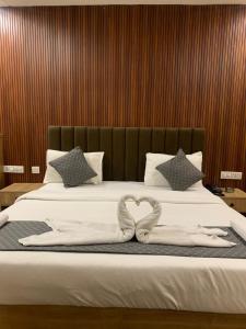 a bed with a heart shaped towel on it at Hotel GS GRAND in Dehradun +17 photos