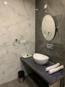 a bathroom with a white sink and a mirror at Hotel GS GRAND in Dehradun