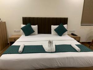 a large bed with two slippers on top of it at Hotel GS GRAND in Dehradun