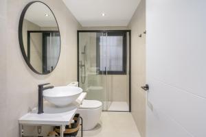 a bathroom with a sink and a toilet and a mirror at Myholidayshome in Palamós +21 photos