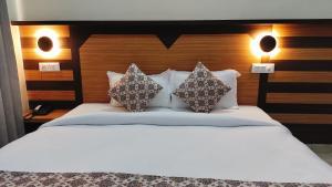 ein Schlafzimmer mit einem weißen Bett und zwei Kissen in der Unterkunft Hotel Nature's View in Dharamshala