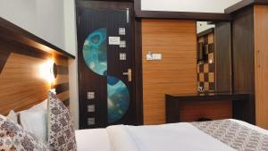 ein Schlafzimmer mit einem Bett und einer Holztür in der Unterkunft Hotel Nature's View in Dharamshala