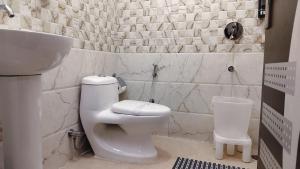 ein weißes Badezimmer mit Toilette und Waschbecken in der Unterkunft Hotel Nature's View in Dharamshala + 28 Fotos