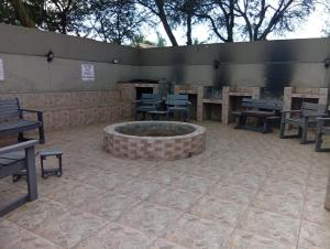 a patio with a fire pit and tables and benches at Vukani Holdings Group in Vanderbijlpark