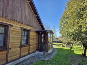 a wooden house with a door on the side of it at Dom Dziadka in Janów Podlaski