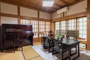 a room with a piano and a table and a dining room at Irest Village Narita in Narita