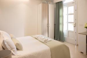 a white bedroom with a bed with towels on it at Fronte Mare Polignano a Mare in Polignano a Mare +89 photos