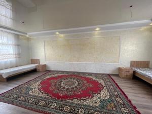 an empty room with a red rug on the floor at Zhailoo Guest House Kochkor in Kochkorka +9 photos