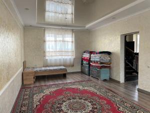 a room with a rug and a bench and a window at Zhailoo Guest House Kochkor in Kochkorka