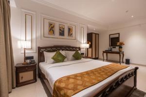 a bedroom with a large bed and a table at The Grand Central in Dona Paula +44 photos