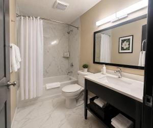 a bathroom with a tub and a toilet and a sink at Super 8 by Wyndham Lexington Park/California Area in California +30 photos