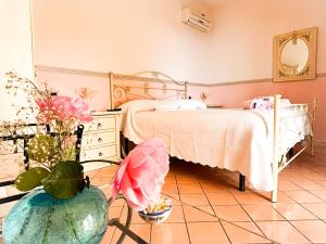 a bedroom with a bed and a vase with flowers at Bed and Breakfast Nefer in Maratea