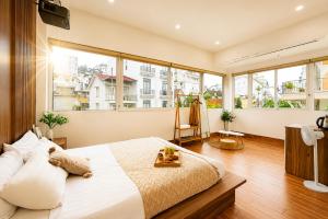 a bedroom with a large bed and large windows at The Morris City Central Boutique in Da Lat