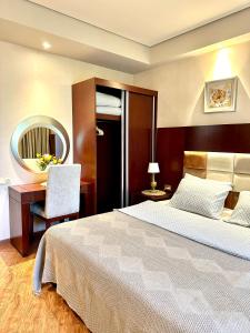 a bedroom with a bed and a desk and a mirror at Beach Dreamland Oasis in Chakvi