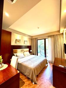 a bedroom with a large bed and a large window at Beach Dreamland Oasis in Chakvi