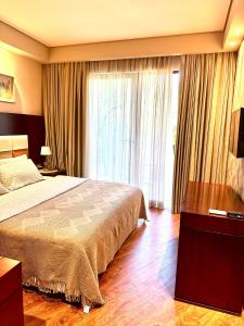 a bedroom with a bed and a large window at Beach Dreamland Oasis in Chakvi