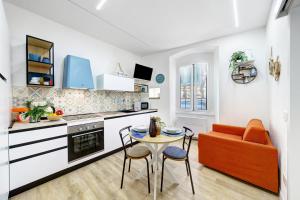 a kitchen with an orange couch and a table at Il Timone e L'Ulivo in Moneglia