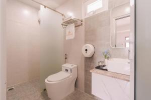 a white bathroom with a toilet and a sink at The Morris City Central Boutique in Da Lat