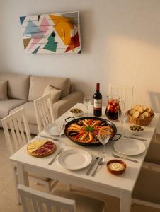 a table with a plate of food and a bottle of wine at Piso Almería playa in Almería