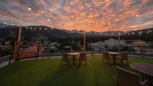 a balcony with tables and chairs and a sunset at Summit Views Hakuba in Hakuba +46 photos