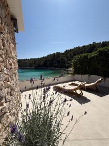 a view of a beach with a bench and the ocean at Apartments Gita in Zavalatica