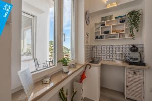 a kitchen with a counter and a window at Casa Leucosia Suites in Capri
