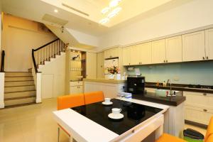 a kitchen with white cabinets and orange chairs at Creekside No.22 B&B in Jiali +48 photos