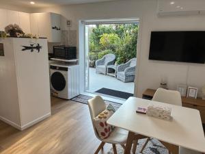 a kitchen and living room with a table and chairs at The Hideaway in Raumati Beach