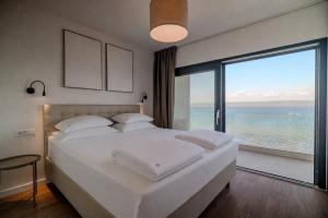 a bedroom with a large bed with a view of the ocean at Courtside Luxury Villa Dalmatia in Dobropoljana +68 photos