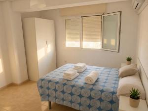 a bedroom with a bed with towels on it at Piso Almería playa in Almería