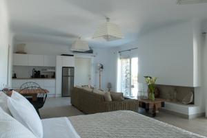 a white living room with a couch and a kitchen at Chrysalis Nature Villa 8 in Kampos Paros