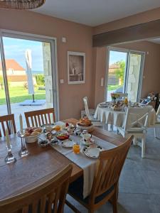 a dining room with a table with food on it at Les Marchettes in Saint-Nexans