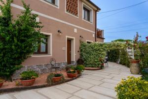 a house with a patio and plants in front of it at Affittacamere il vecchio fienile in Ameglia