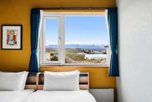 two beds in a room with a window at Silvale in Kami-furano
