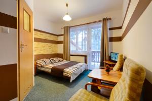 a hotel room with a bed and a desk at Zimorodek poczuj z nami magię Karpacza in Karpacz
