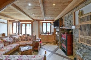 a living room with a couch and a stone wall at La Ferme D'aurélie in Montvalezan