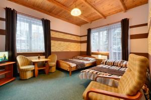 Habitación con 2 camas, mesa y sillas en Zimorodek poczuj z nami magię Karpacza, en Karpacz