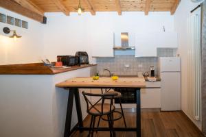 a kitchen with a counter with two bar stools at Affittacamere il vecchio fienile in Ameglia