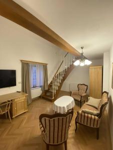 a living room with a tv and a staircase at Rezidence Zvon in Znojmo