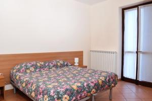 sypialnia z łóżkiem z narzutą w kwiaty w obiekcie Residenza San Rocco w Asti