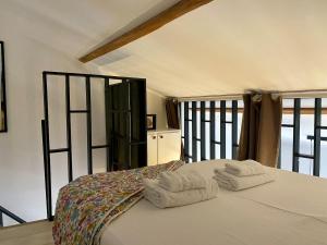 ein Schlafzimmer mit zwei Handtüchern auf einem Bett in der Unterkunft Duplex studio Moulleau proche plage avec chambre en mezzanine in Arcachon
