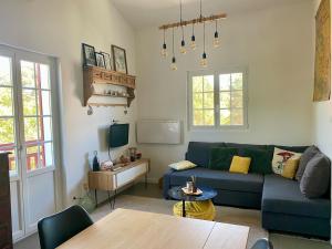 ein Wohnzimmer mit einem blauen Sofa und einem Tisch in der Unterkunft Duplex studio Moulleau proche plage avec chambre en mezzanine in Arcachon