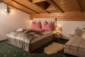 een slaapkamer met een bed met roze kussens bij Landhaus Alpenjuwel in Sankt Johann im Pongau