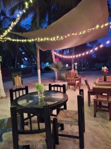 a table with chairs and an umbrella with lights at Beachfront Casa Maya Lodge in El Cuyo