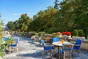 a patio with tables and chairs and plants at Ensana Thermal Hévíz in Hévíz