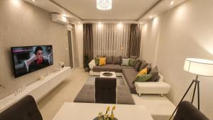 a living room with a couch and a tv on a wall at Luxury Apartment Paraćin - River View in Paraćin