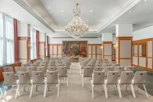 an empty room with chairs and a chandelier at Ensana Thermal Hévíz in Hévíz +28 photos