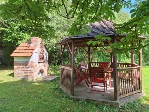 a wooden gazebo with chairs and a table at Gergócs Vendégház in Őriszentpéter
