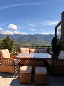 a patio with a table and chairs and mountains at Villa Kapreshumi in Itʼkhvisi