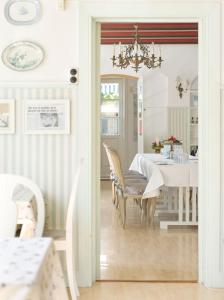 a dining room with a table and a chandelier at Hotel Villa Brinkly in Snekkersten